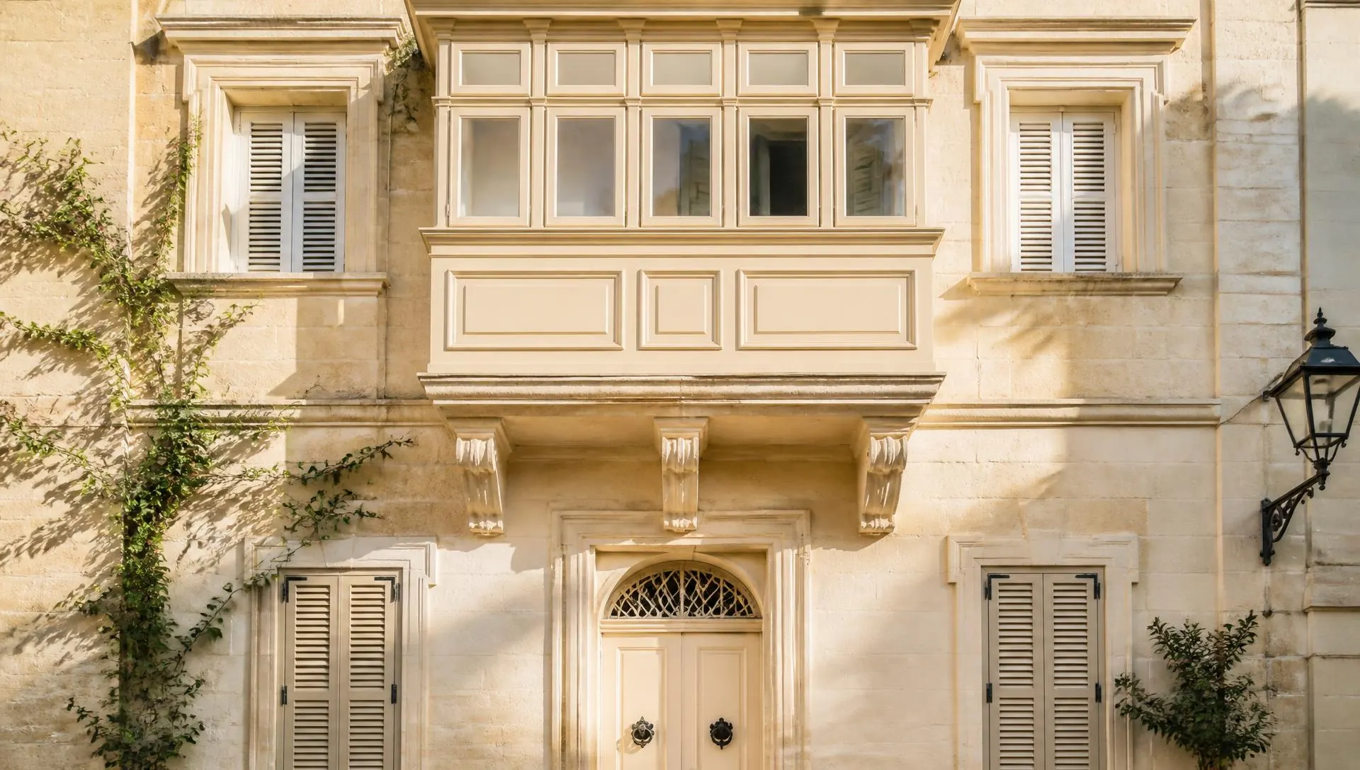 Valletta townhouse facade in Malta with a traditional timber balcony in morning light
